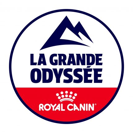 Cercle aux contours bleus. Au centre, un texte en capitales bleues : La grande Odyssée. Juste en haut, un graphisme bleu représentant des montagnes. Le tiers inférieur du cercle est rempli de rouge, et on peut y voir, en blanc, le logo de l'entreprise Royal Canin.